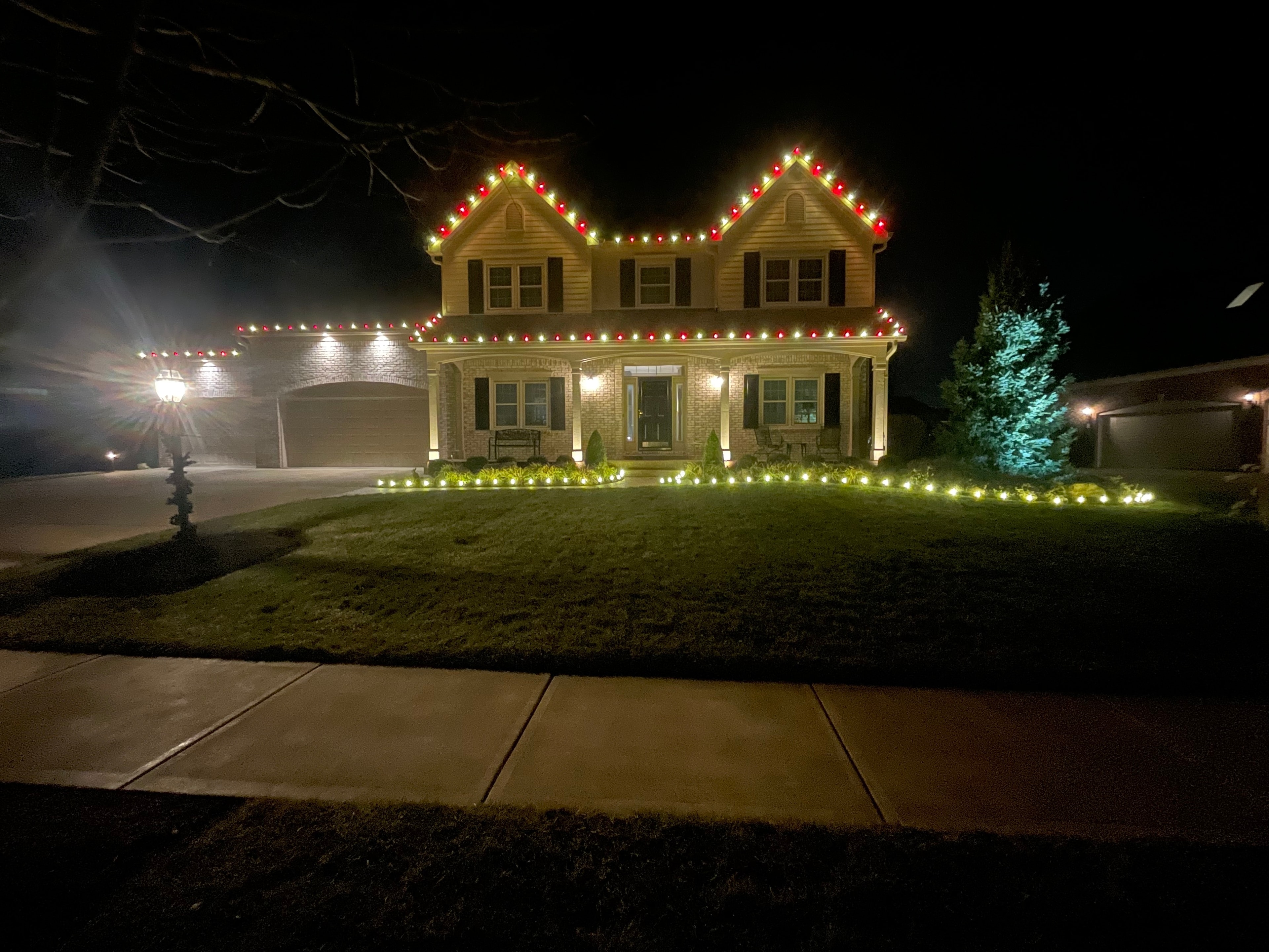 Large home with full colorful Christmas light display at night