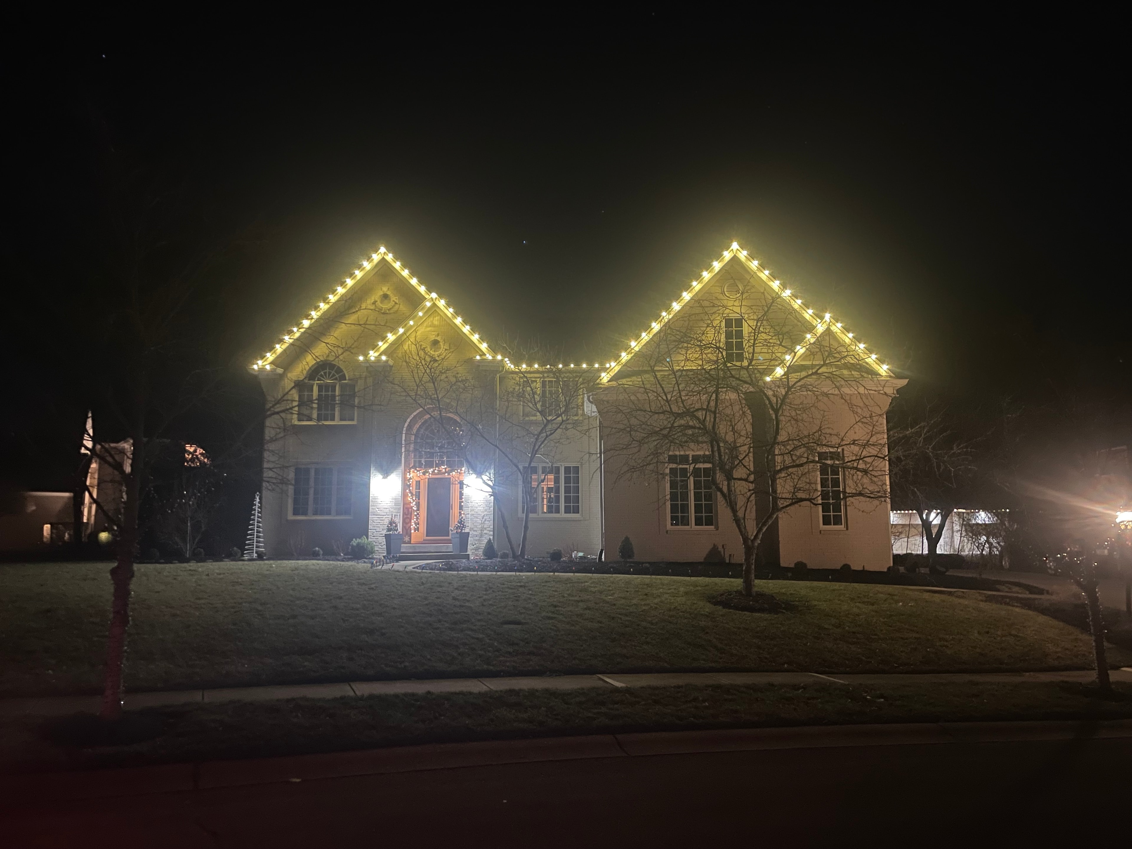 Icicle lights hanging from eaves in winter night