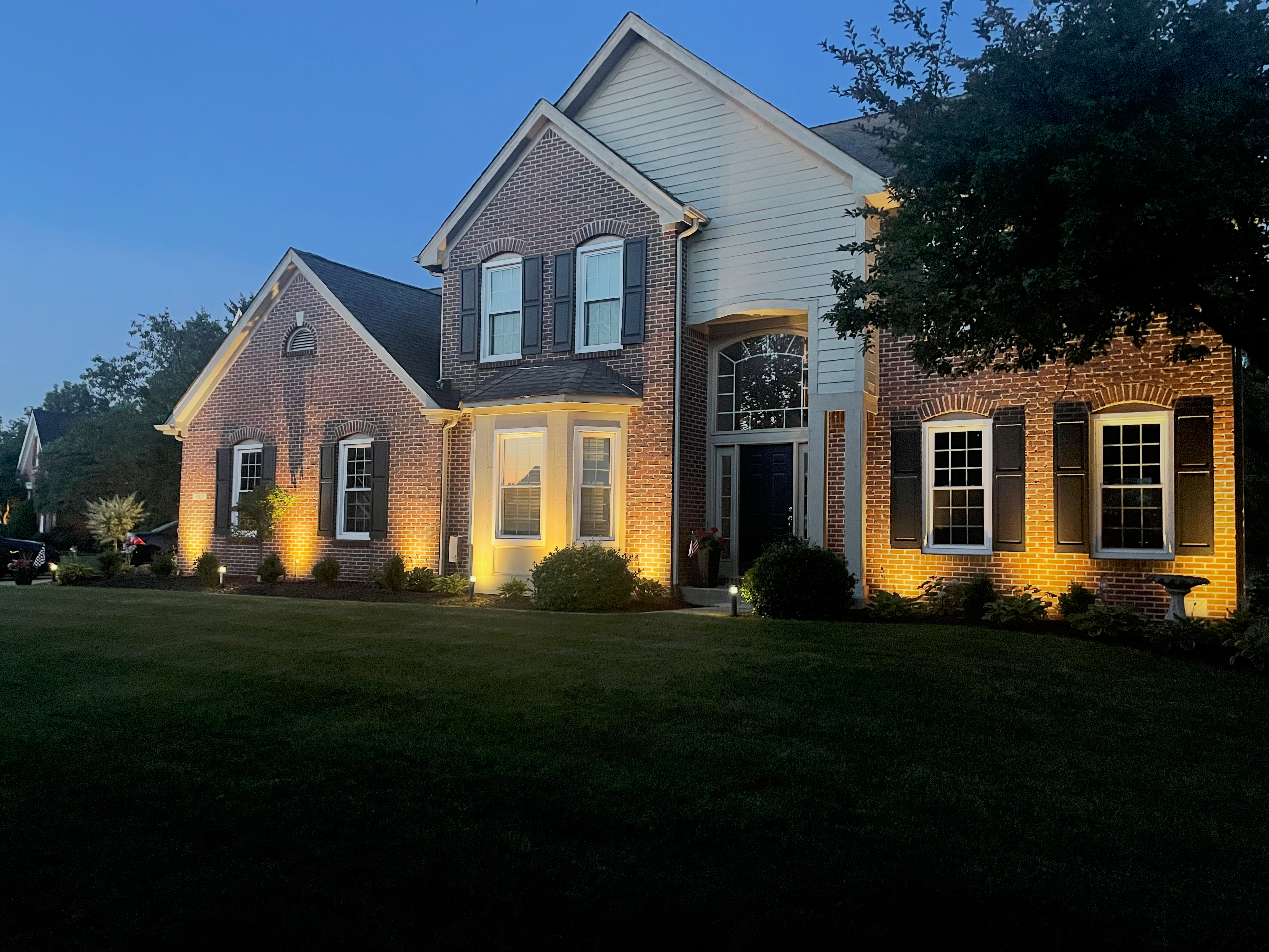 Landscape uplighting on trees and garden at night