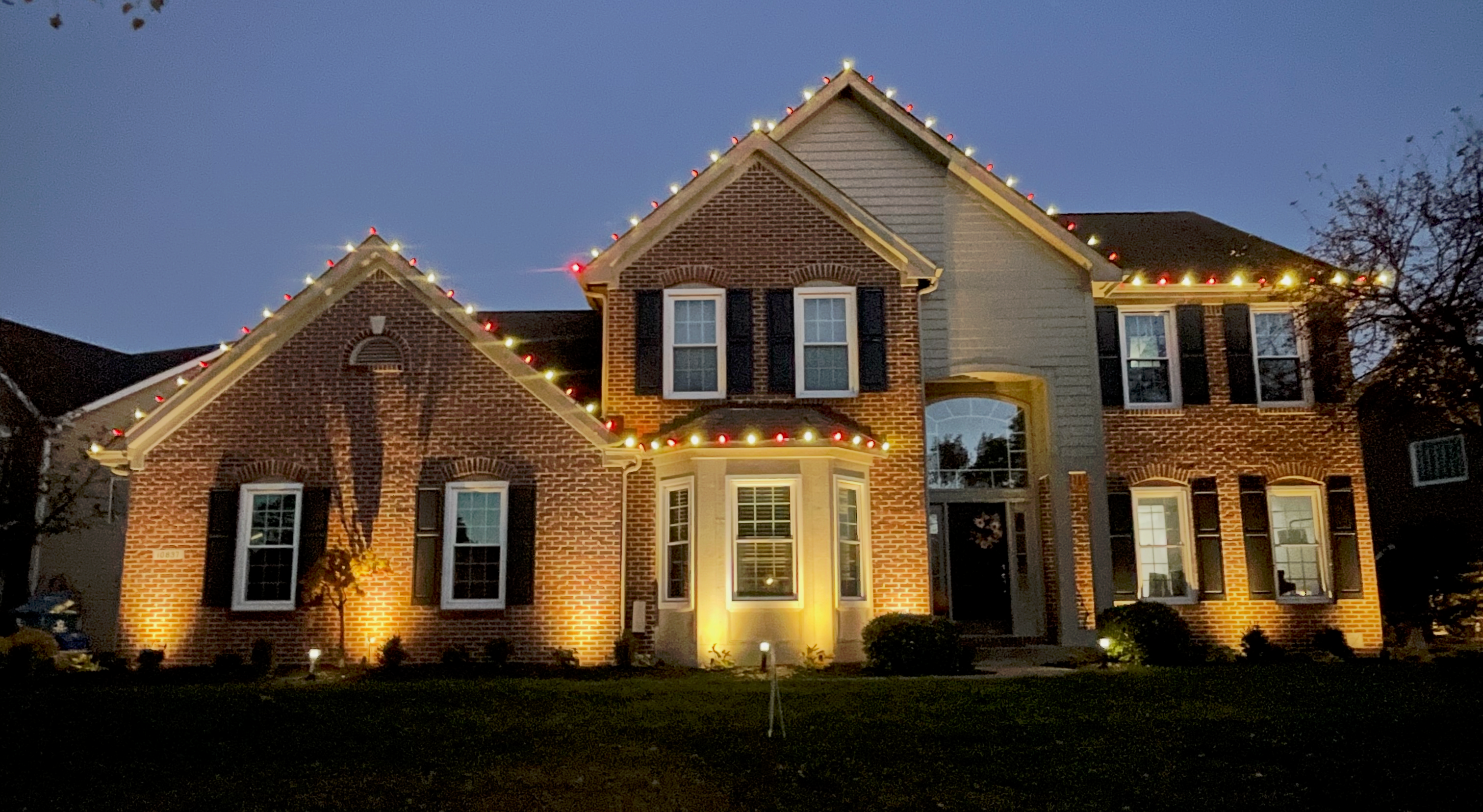 Beautiful neighborhood home exterior with warm outdoor lighting