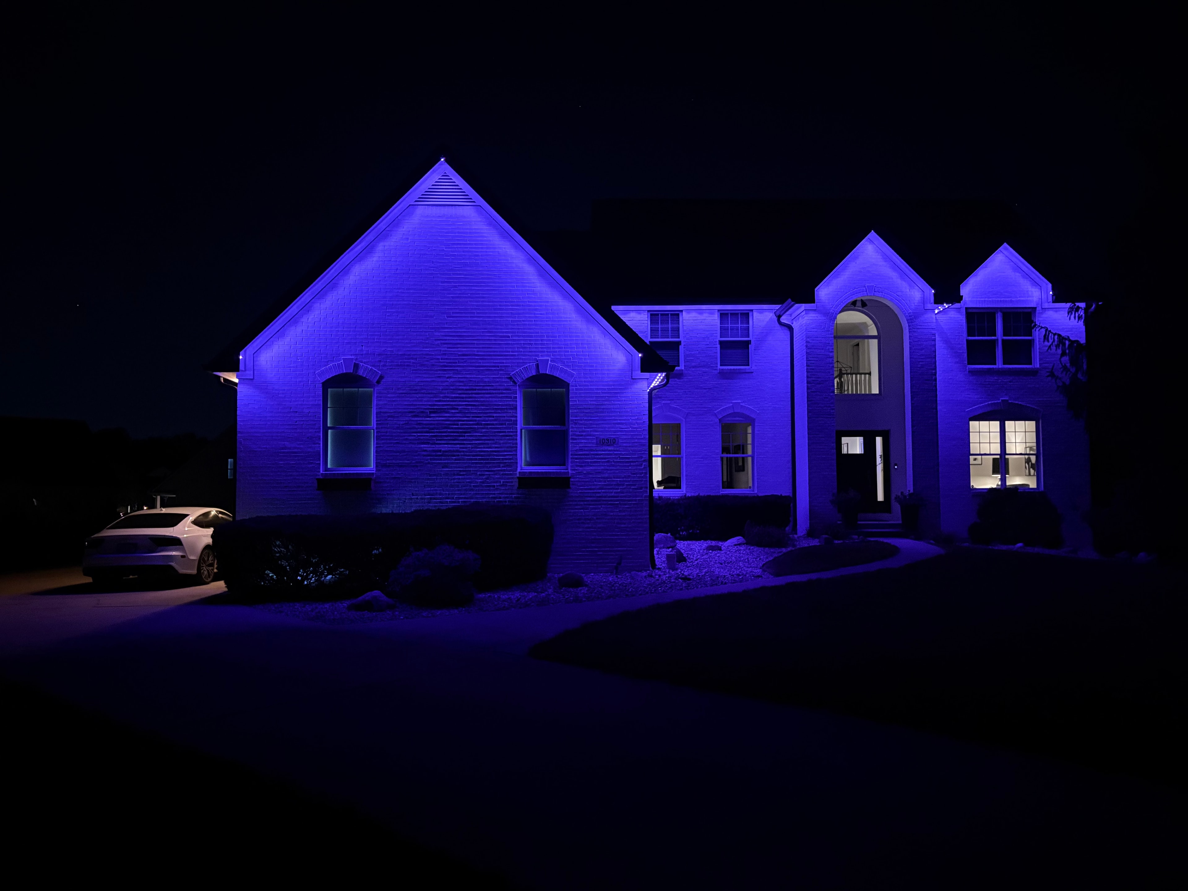 Home illuminated in blue permanent LED roofline lighting