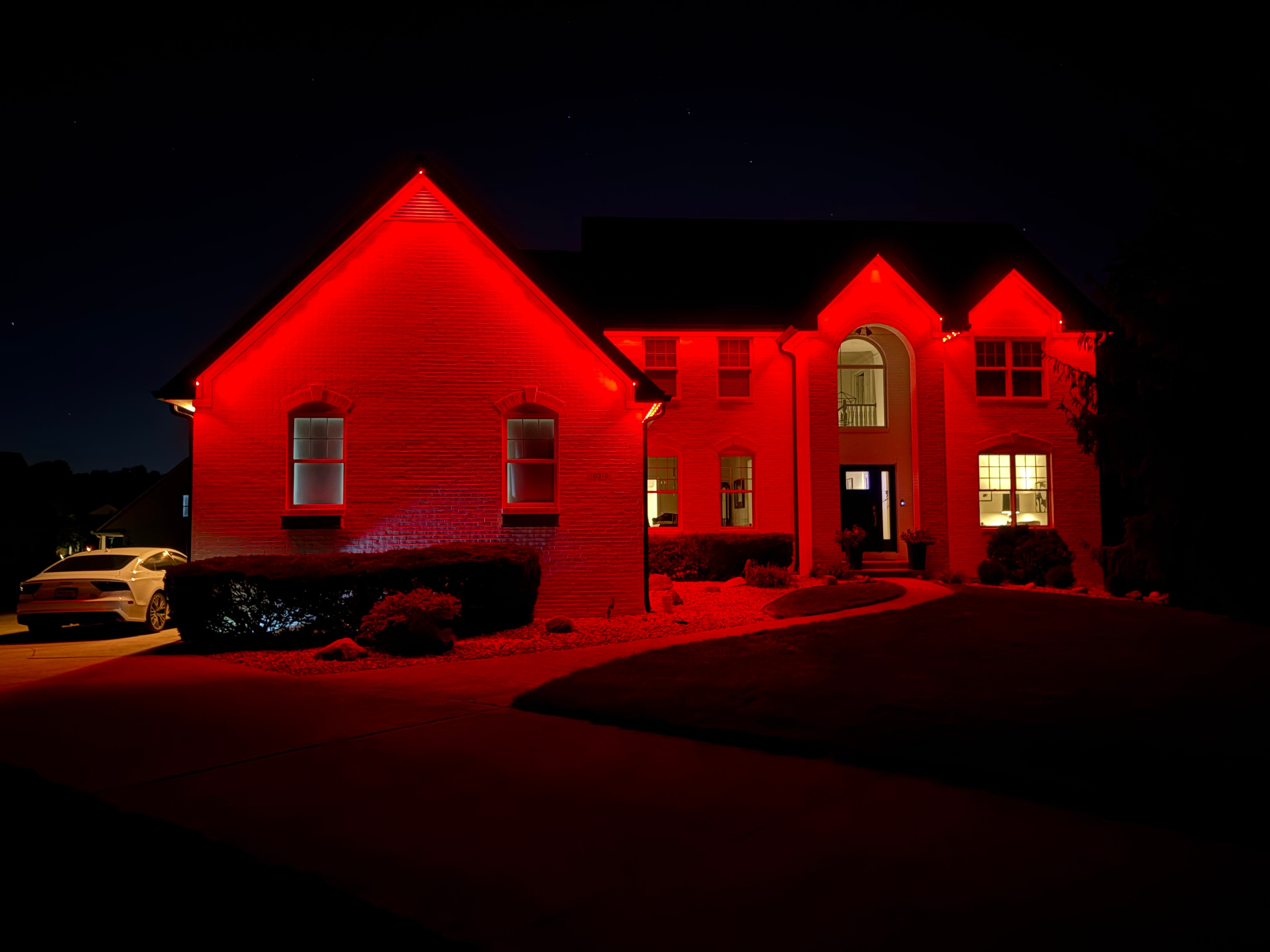 Home illuminated in red permanent LED roofline lighting